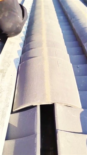 Roofer Installing Grey Ridge Tiles With Precision And Speed