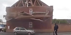 The moment a house wall collapses due to strong winds in England - a person who was passing by escaped unharmed