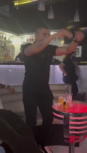 Energetic Dance Moves in a Modern Bar Setting
