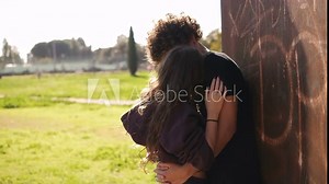 love, romance - young couple passionately kisses at the park