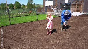 Cute girl daughter help father dad with lawn grass seeding sowing in house yard.