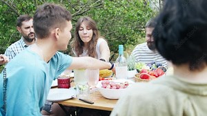 Happy friends having fun outdoors. Group of friends having backyard dinner party together.