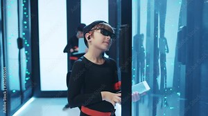 Young boy hacker opening server cabinet, copying network data into a tablet, taking part in important secret mission with friends. Spy kids. Data center cybercrime.