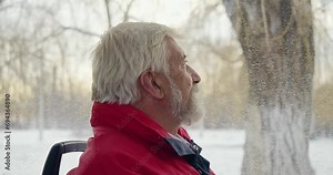 Side view of pasenger going by bus driving. Old male wearing red jacket, with grey hair and wrinkles, sitting looking up tgrough window, enjoying nature. Concept modern routine