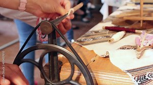 Woman using an antique winder for wrapping yarn onto a spool