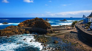 A scenic coastal road curving around rugged ocean rocks