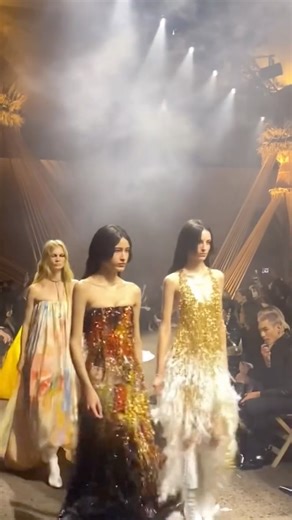 V Magazine on Instagram: "@sean.mcgirr continues to rewrite the rulebook at @alexandermcqueen. For his latest SS26 collection, ritual met rebellion as the designer unveiled a sensual, unfiltered vision of modern McQueen. Exploring beauty’s darker roots, the collection balanced cropped leather jackets and ultra–low-rise pants with soft, layered dresses and floral-covered knits. Revisiting the house’s iconic codes—the skull scarf, the bumster, and the marching band jacket—McGirr reimagined them th