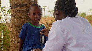 Female woman black doctor listening heart rate beat of african children in small village, medical healthcare charity clinic hospital