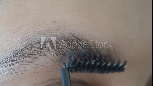 CloseUp of Brow Grooming Using Spoolie Brush beauty technique for eyebrow care and styling