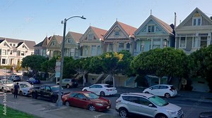 Painted Ladies Victorian houses. Historic Victorian style houses and trees growing under cloudy sky at Alamo Square in California.
