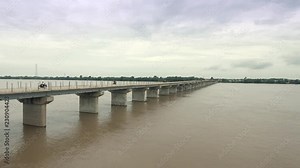 Aerial drone shot : fly back revealing motorbikes crossing a new bridge almost finished