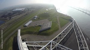 Aerial low flight over arm Maeslantkering Maeslant barrier part of Delta Works Deltaworks Delta Werken bird-eye view storm surge barrier Rotterdam harbour one of largest moving structures on Earth 4k