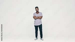 Smiling african man in eyeglasses looking at camera and smiling on white background. Full length of a happy black guy standing with his arms crossed.