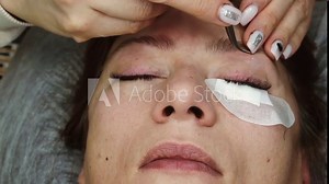 The process of eyelash extension in a woman.