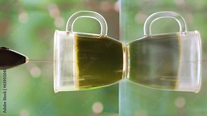 Process making matcha green tea. Green matcha tea powder falls into a glass cup from the spoon. Traditional Japanese drink. Mixing matcha tea with whisk. Healthy matcha drink. Vertical video