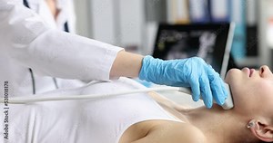 Ultrasound of larynx of thyroid gland to woman in clinic