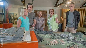 group of people view a scale model of the town. Guide explain the details Stock Video