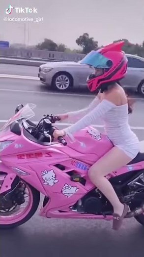 Girl rides her pink motorcycle wearing a tight dress