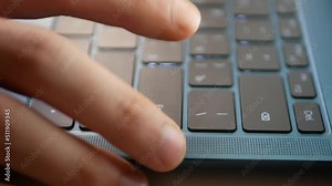 Typing and hitting the enter key on a small laptop keyboard.