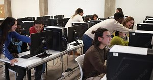 Young multiracial students using computer inside classroom at college university