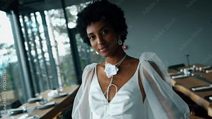 A dark-skinned bride in a white dress poses in the mountains on the terrace. Wedding concept. Portrait of a dark-skinned bride 4k