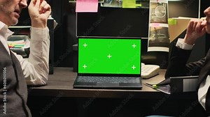 Inspectors review greenscreen on laptop, working together in incident room. Police officers looking at chromakey display with isolated template, evaluating forensic evidence and proof.