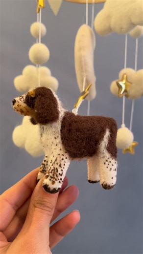 A one-of-a-kind baby mobile for a one-of-a-kind love 🤍 This custom Springer Spaniel was **needle-felted by hand using shaggy sheep wool** to capture every soft wave, floppy ear, and sweet little detail of mom’s *first fur baby*. Handmade baby mobiles aren’t just nursery decor — they’re **keepsakes**. They tell a story. They hold memories. And they quietly watch over baby while he naps, rests, and dreams beneath the gentle presence of the dog who was loved first 🐾 Timeless. Sentimental. Made wi