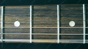 Close up of guitar string vibrating during playing. Cord being strummed and seeing it vibrate. Trembling against fret. Beautiful background with wooden texture. Music performance. Slow motion Stock Video