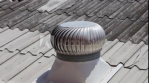Ventilation turbines rotate on the roof. The metal ball ventilator on the tile roof rotates rapidly on hot days to regulate building temperature.