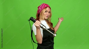 Young blonde girl using hand blender extending hands to the side and inviting to come over isolated background on green screen chroma key