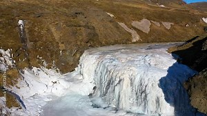 Waterfalls and ice in winter. Famous waterfall landscape in Iceland. Frozen waterfall, a magical winter location of snow and ice. Beautiful freezing nature.