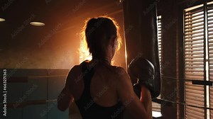 Women self defense girl power. Strong woman fighter training punches on boxing ring. Healthy strong girl punching boxing bag. Training day in boxing gym. Strength fit body workout training