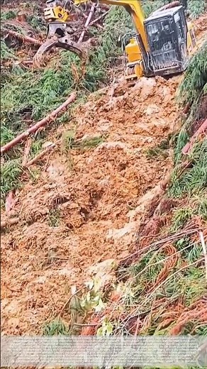 Excavator clearing mud from mountain road