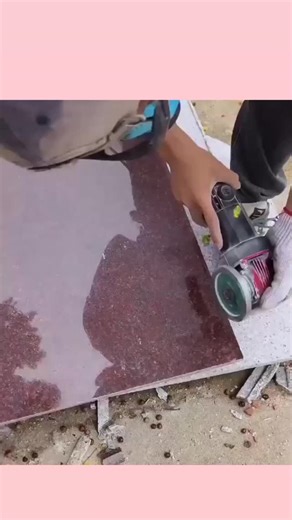Daily Dose BD on Instagram: "In the bustling construction hubs of South Asia, the ancient tradition of stone masonry is evolving with the use of modern power tools. A skilled artisan is seen here performing a "Precision Etch" on a high-grade red granite slab, turning a structural component into a decorative masterpiece. Using a specialized diamond-tipped abrasive wheel, the worker maintains a perfectly straight trajectory to create recessed geometric patterns that define luxury interior finishes
