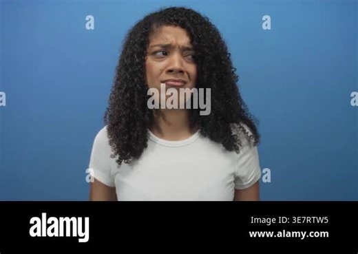 African american woman finger pointing to head with curly hair and perplexed gaze in studio; doubt thinking Stock Video Footage - Alamy