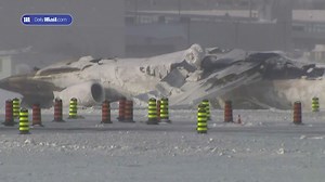 Investigators examine the wreckage of the Toronto passenger jet crash