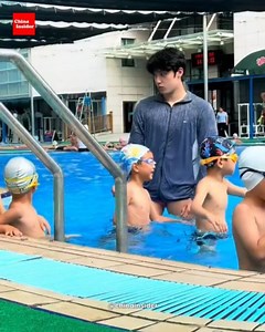 China Insider on Instagram: "A swimming coach in Hangzhou has gone viral — and it’s not just because of his freestyle 🏊‍♂️💦. Videos of the tall, handsome coach patiently guiding kids at the elite Chen Jinglun Sports School have splashed all over social media. Moms are lining up to “drop off” their kids and sneak a few pics 📸. One joked, “I’ve never seen moms so punctual for swim class!” Another warned, “Dads, beware — he’s got the six-pack and the patience 😳Ǵ