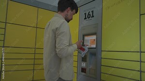 Male customer using self-service automated delivery terminal to send package or storage locker to drop off parcel. Postal automatic package pickup point man at operating screen holding phone and box.