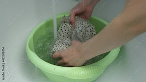 Woman is rinsing her dress in bathroom under a stream of water by hands, closeup hands. Laundry by hands. Washing at home, housekeeping and housework.