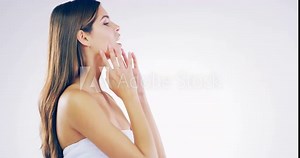Wink, facial and face of woman in studio for wellness, beauty and spa treatment. Dermatology, salon and portrait of isolated person touch for grooming, cosmetics and skincare on white background