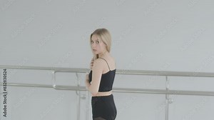 Fit girl in black clothes performing contemporary. Female dancer shows flowing motions, body and hands waves at white room. Modern ballet dance choreography. Young woman is moving smoothly Stock Video