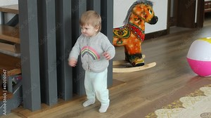 Baby making first steps. Kid learning how to walk