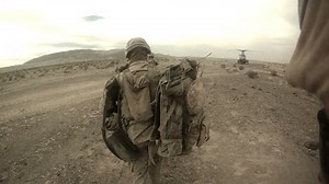 Live action of Marines running in desert for combat loading on a helicopter in the Middle East.Troops running to military helicopter after armed conflict and special operations mission.