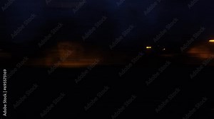 Panorama of the night city is blurred in motion. A view from the window of a train or a car on the night city in motion.