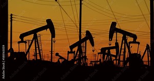 A nodding donkey pumps crude oil up from the ground well on an oil field