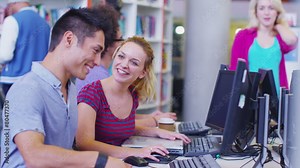 Diverse student group working and studying together in college library.