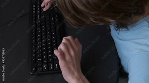 Programmer typing rapidly on a black keyboard, creating code for software development in a modern office environment