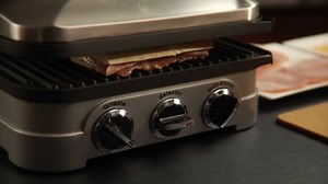 chef removes panini sandwiches from grill