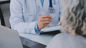 Close up of Female Doctor using stethoscope putting beat heart diagnose with patient in examination room at a hospital, check-up body, Medical and Health Care Concept.