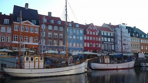 Nyhavn Harbor in Copenhagen. Famous tourist spot in Denmark with colorful historical buildings and boats on Nyhavn waterfront. Traveling in Scandinavian country
